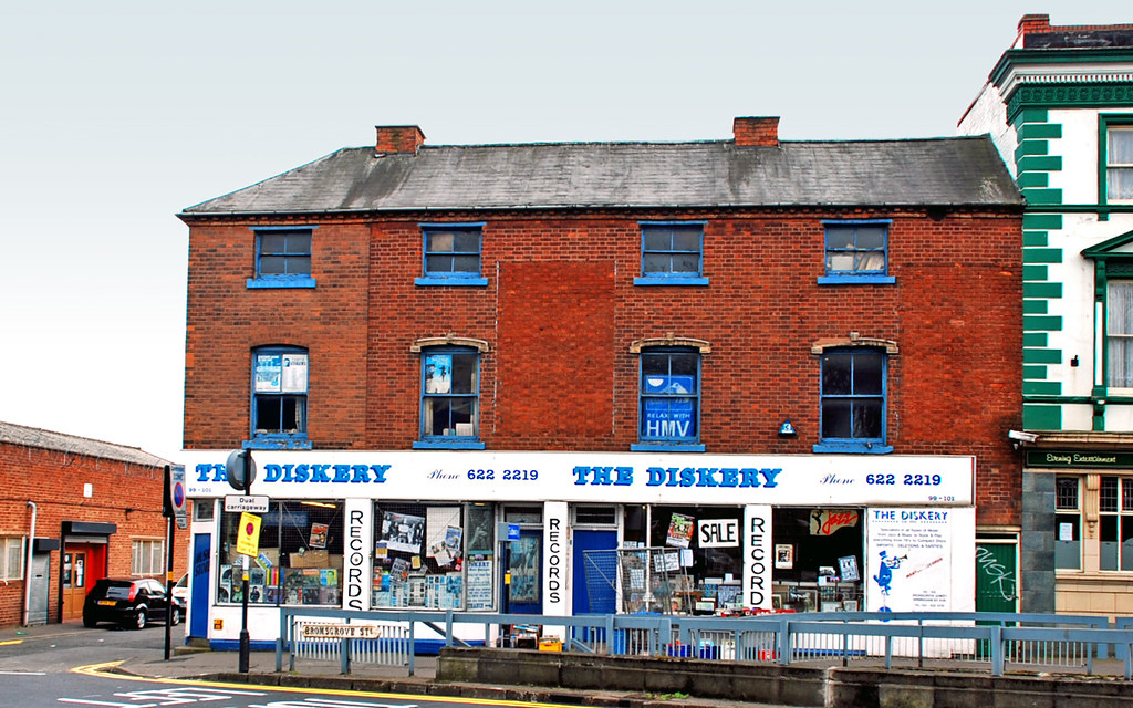 The Diskery seen from across Bromsgrove Street, full width of the terrace, blue fascia and red brick
